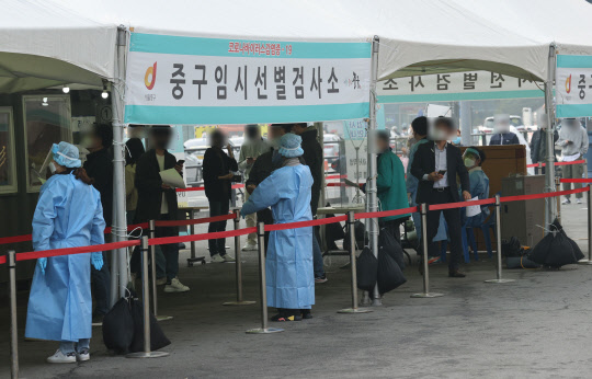 26일 서울역 광장 중구 임시선별검사소에서 시민들이 신종 코로나바이러스 감염증(코로나19) 검사를 위해 차례를 기다리고 있다. 정부는 이날 '코로나19 대응' 중앙재난안전대책본부 회의에서 다음 주부터 2주 동안 지금의 사회적 거리두기 단계(수도권 2단계, 비수도권 1.5단계) 및 5인 이상 모임금지 지침을 그대로 유지하기로 결정했다. 연합뉴스